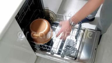 一个男人把<strong>脏盘子</strong>放进洗碗机